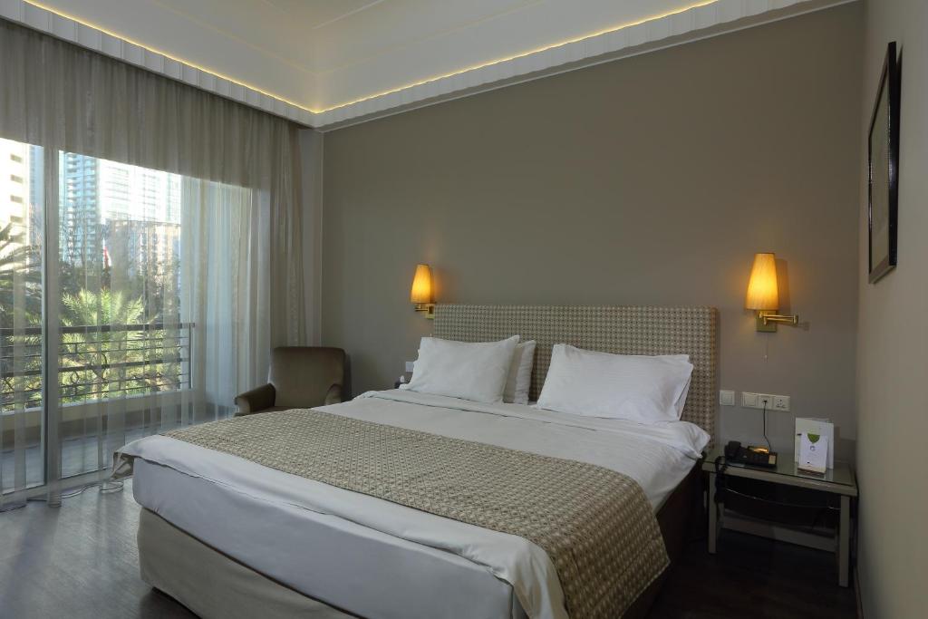 a hotel room with a large bed and a window at Warwick Palm Beach Hotel in Beirut