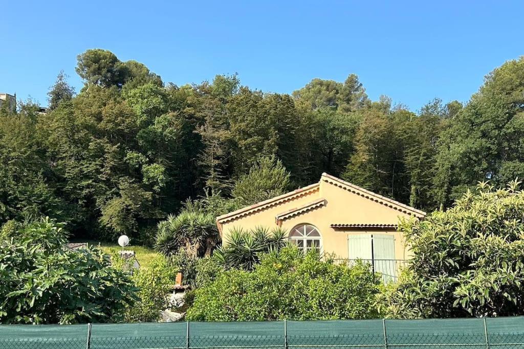 une maison jaune devant une colline avec des arbres dans l'établissement Villa Lily à 10 min de l'aéroport de Nice, à Cagnes-sur-Mer