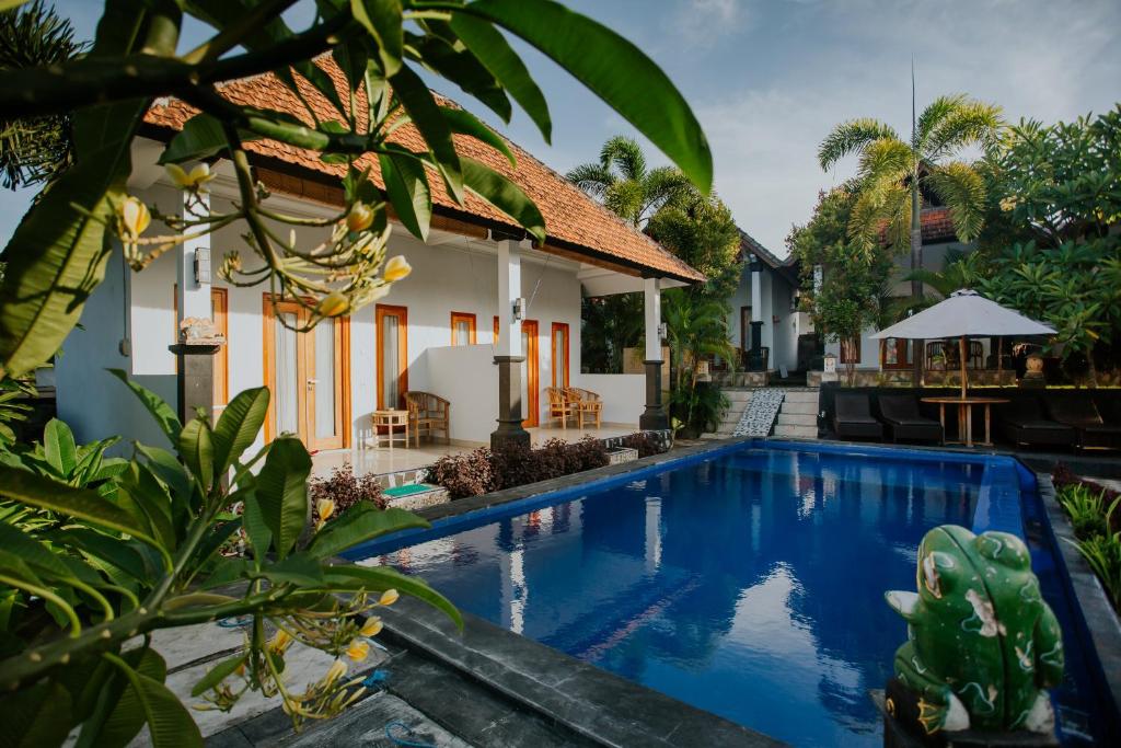 a villa with a swimming pool in front of a house at The Dagan Bungalow in Nusa Penida