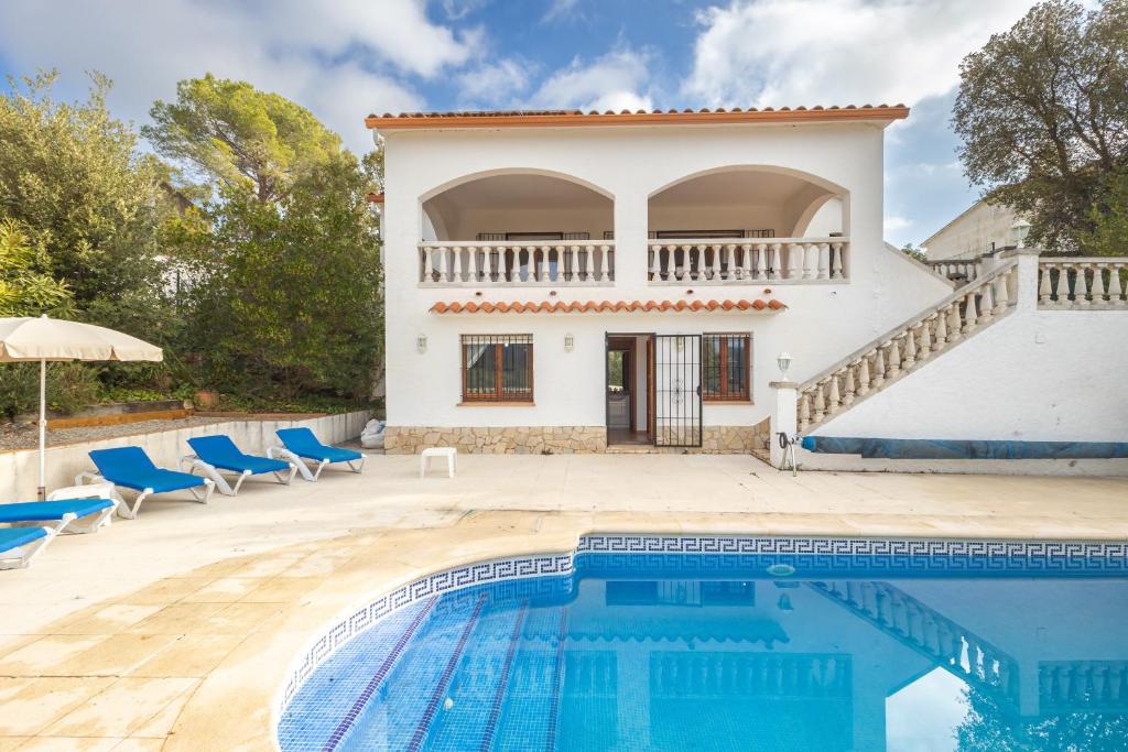 eine Villa mit einem Pool vor einem Haus in der Unterkunft La Calma in Calonge