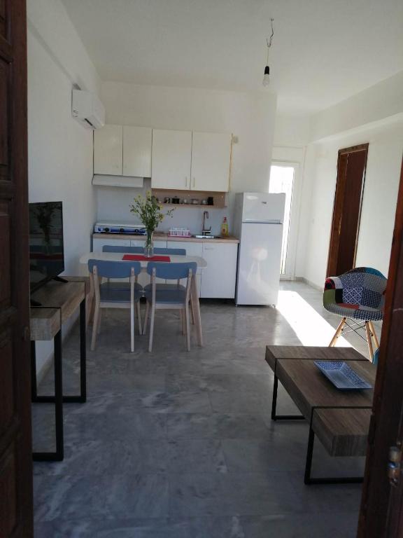 a kitchen with a blue table and a white refrigerator at Cozy Rodas House 1 in Skála