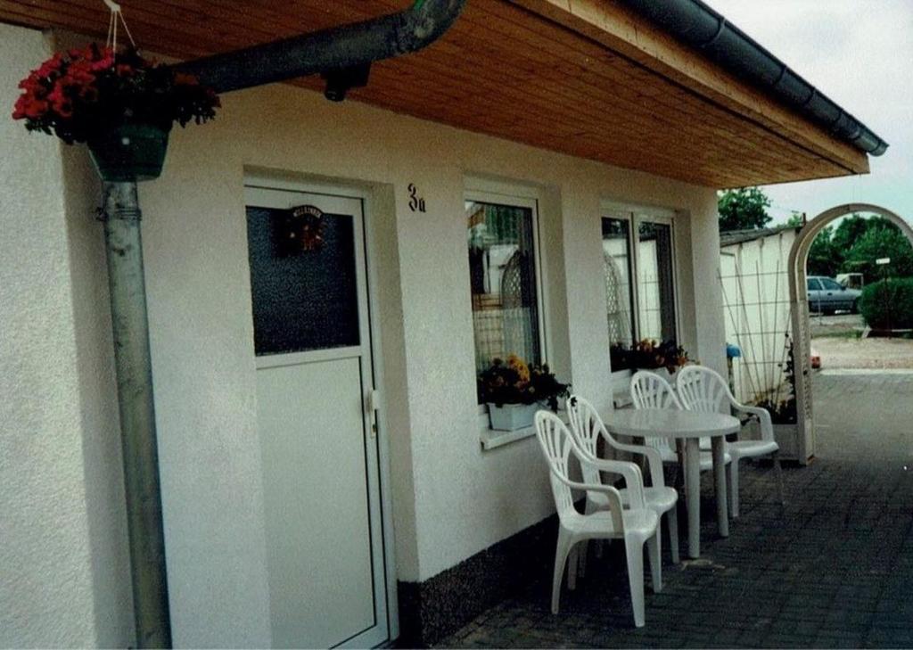 un patio con tavolo, sedie e un edificio di Albrecht - ABC207 a Wismar