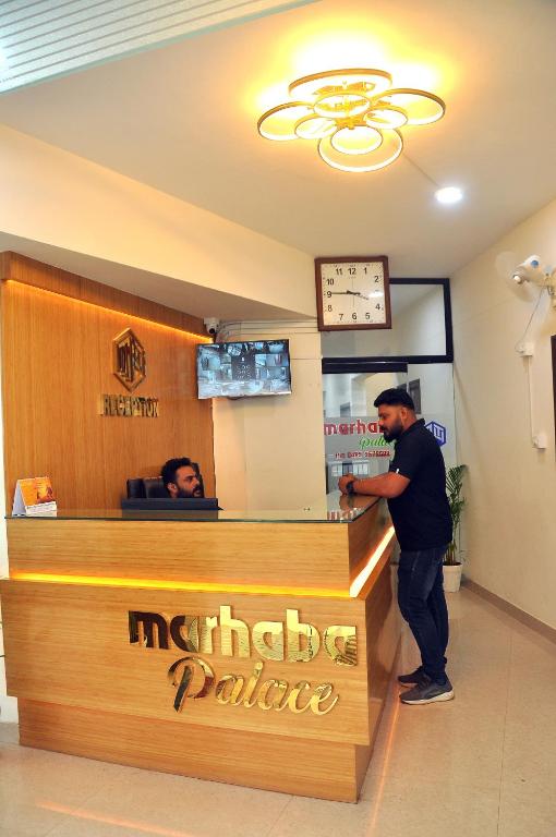 コーリコードにあるMARHABA PALACEのレストランのカウンターに立っている男性