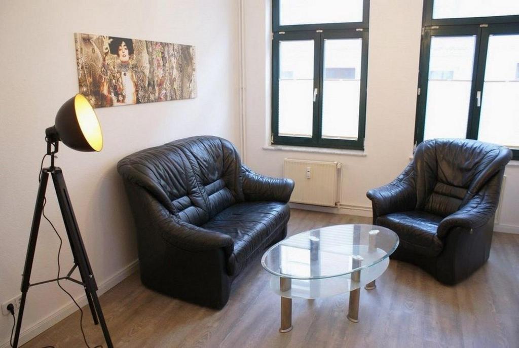 sala de estar con 2 sillas y mesa de cristal en Altstadtleben - ABC164, en Wismar