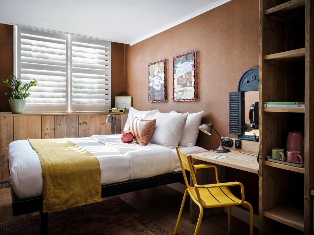 Un dormitorio con una cama y un escritorio con una silla. en Max Brown Hotel Museum Square, part of Sircle Collection, en Ámsterdam