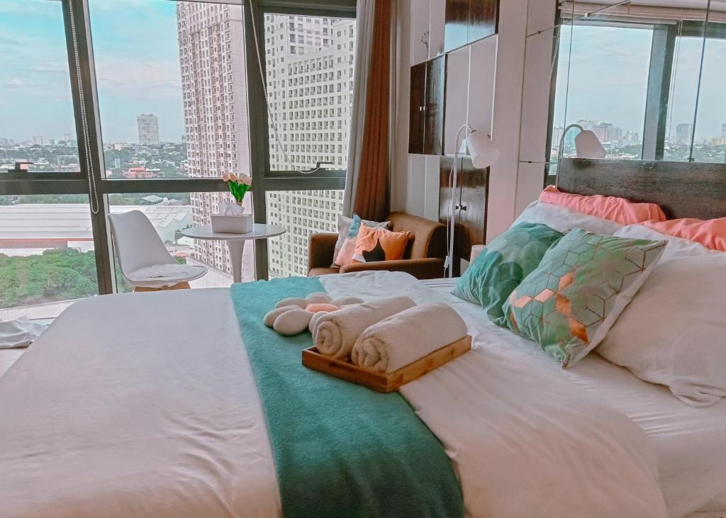 ein Schlafzimmer mit einem großen Bett mit Handtüchern darauf in der Unterkunft Casabay Suite Eastwood Staycation in Manila