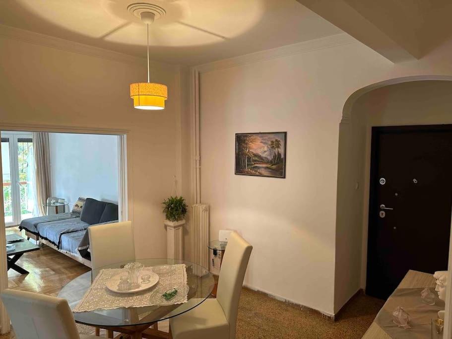 uma sala de estar com uma mesa e um sofá em Elegant XL Apartment In Koukaki em Atenas