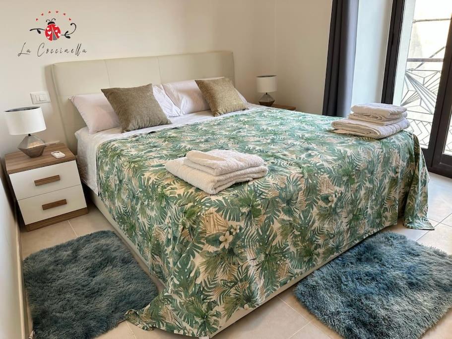ein Schlafzimmer mit einem großen Bett mit Handtüchern darauf in der Unterkunft La Coccinella in Graniti