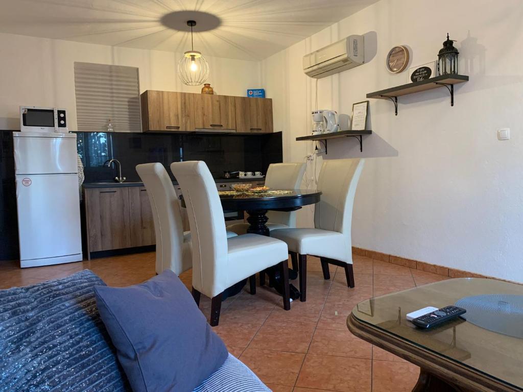 a living room with a table and chairs and a kitchen at Apartman Nina in Karlobag