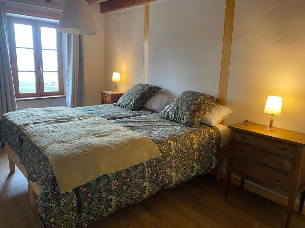 a bedroom with a bed with two lamps on it at Chambre 2 in Chalmazel Jeansagniere