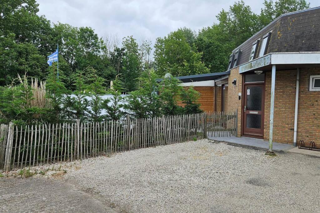 einen Zaun vor einem Haus mit einer Holztür in der Unterkunft Liguster 59* in Nieuwvliet
