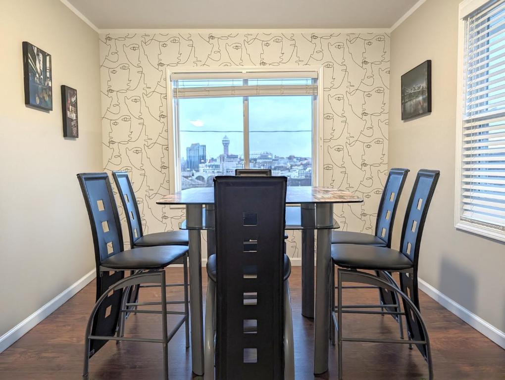 uma sala de jantar com uma mesa e cadeiras e uma janela em Niagara Apartment em Niagara Falls