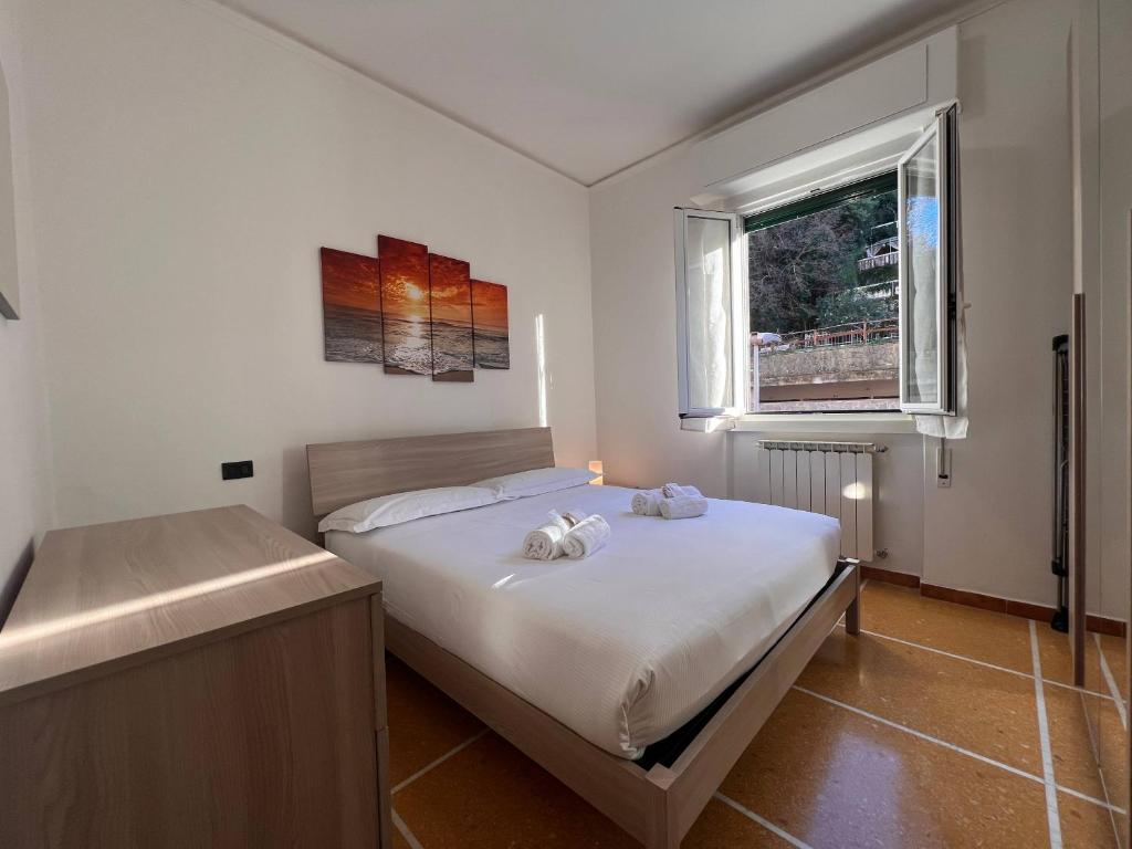 een slaapkamer met een bed met witte lakens en een raam bij Relax & Mare in Rapallo