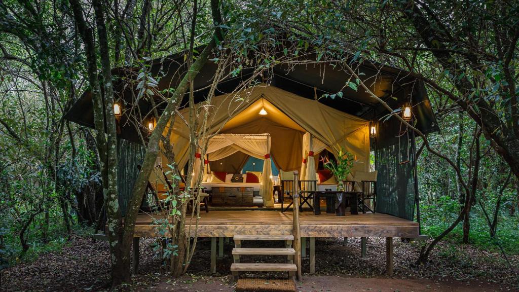 a tent in the woods with a wooden deck at Soroi Mara Bush Camp in Masai Mara