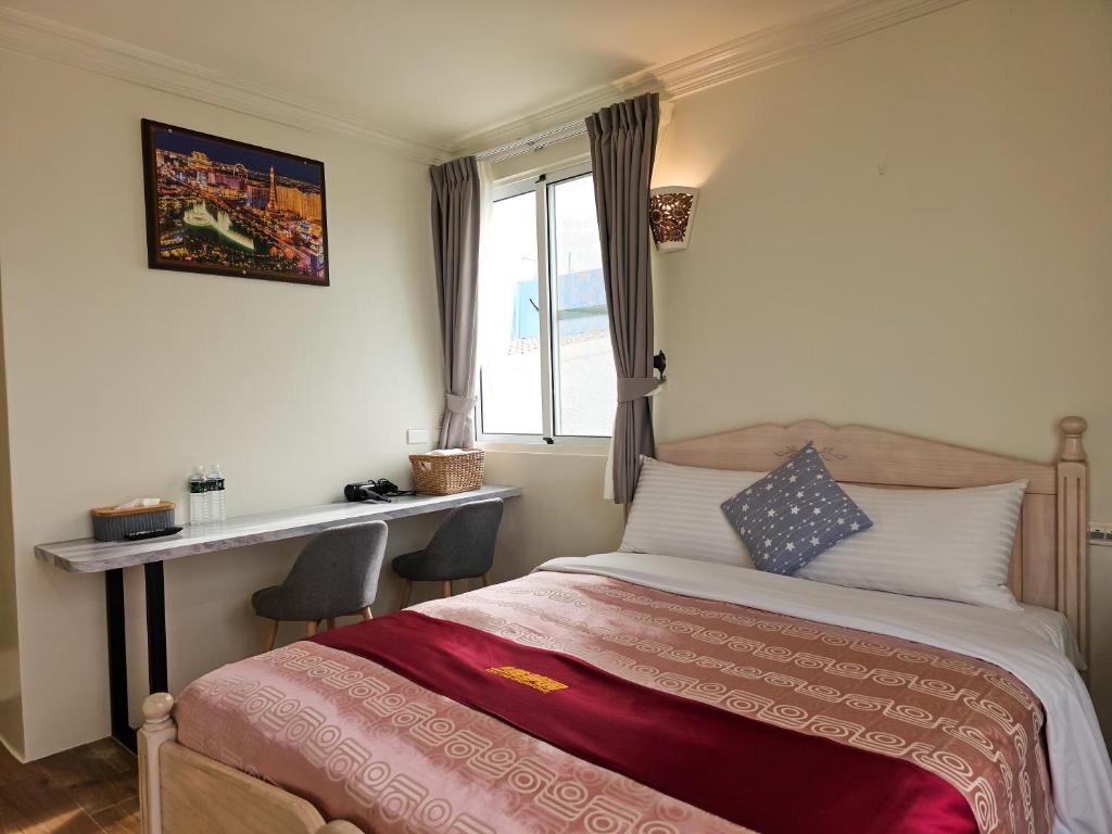 a bedroom with a bed and a desk and a window at Kenting Garden Homestay in Kenting