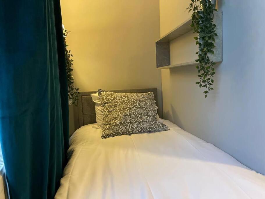 a bed with a pillow on top of it at Single Bright Studio Flat in King's Cross in London
