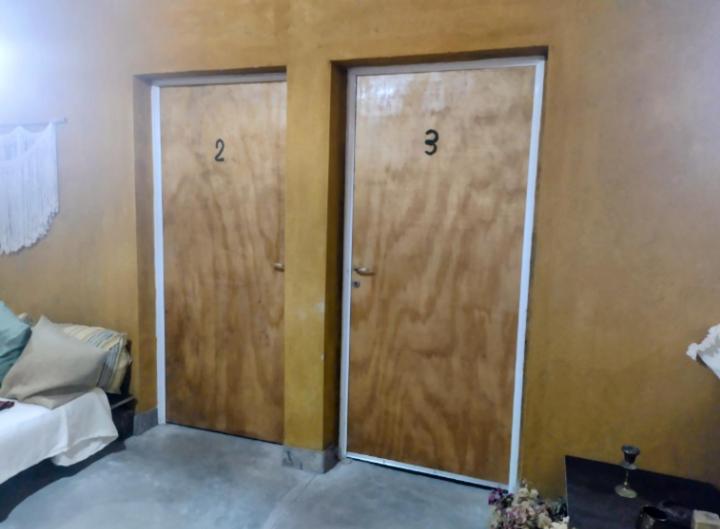 2 puertas de madera en una habitación con cama en Pomancillo Ecolodge 