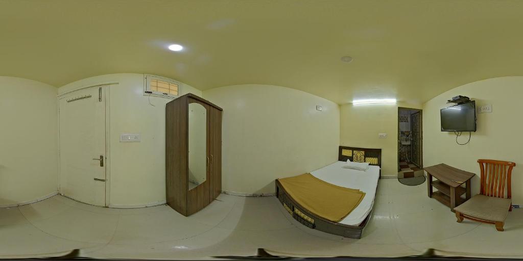 a room with a bed and a table and a tv at Hotel Garden Residency By WB Inn in Bangalore