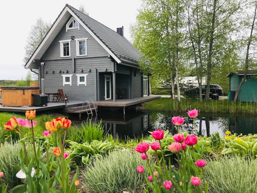 una casa en un muelle con flores en primer plano en Ermistu Puhkeküla en Ermistu