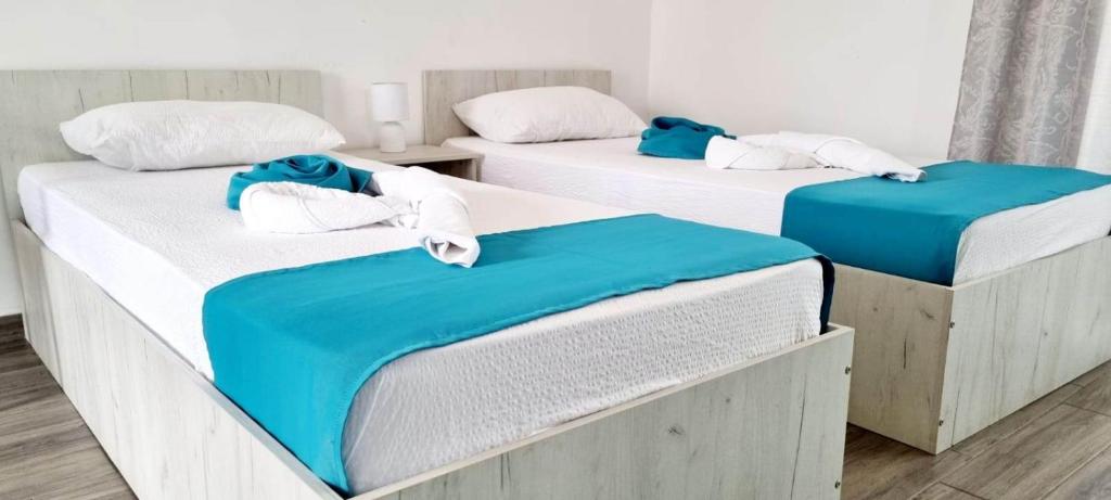 three beds in a room with blue and white at Studiouri Techirghiol in Techirghiol