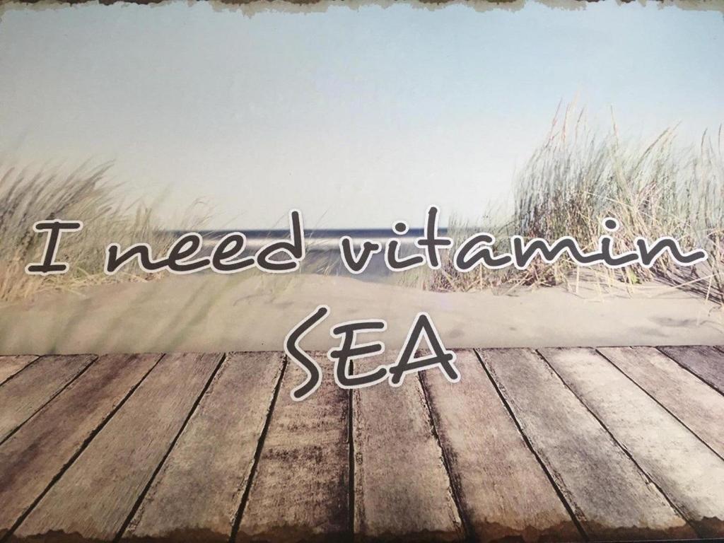 een foto van een houten terras met de woorden die ik nodig heb vitamine zee bij Fewo Claudia - ABC332 in Neuburg