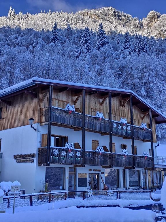 ein Gebäude mit einem Balkon mit schneebedeckten Bäumen in der Unterkunft Les Chemins du Léman in Novel
