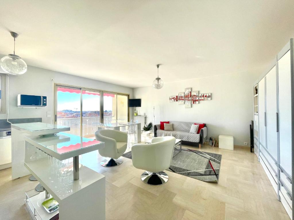 un salon avec une table en verre et des chaises dans l'établissement Petit Juas by Welcome to Cannes, à Cannes