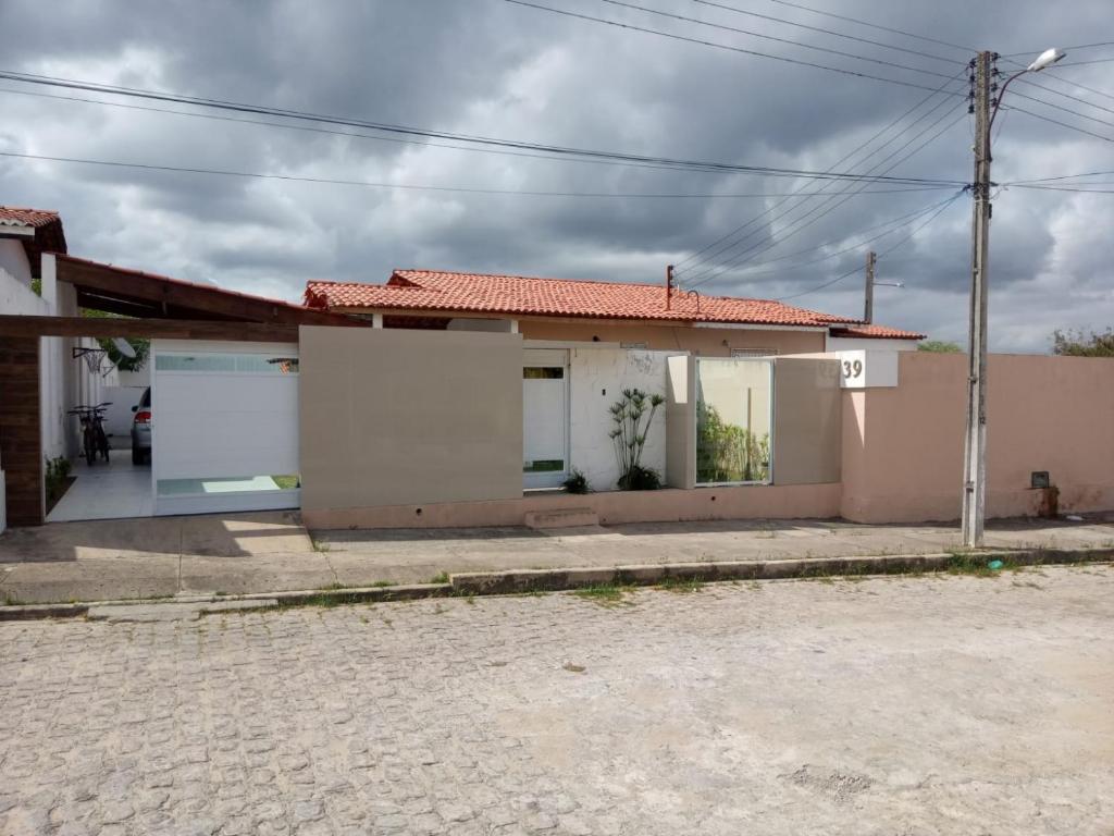 een klein wit huis met een rood dak bij Aconchego do velho chico in Piranhas
