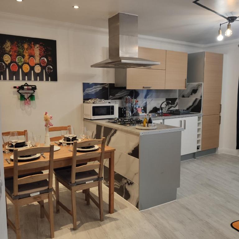 a kitchen and dining room with a table and chairs at Stunning 2-Bed Apartment in London Dagenham in Dagenham