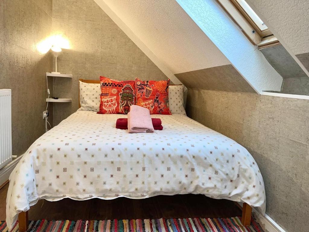 a small bedroom with a bed in a attic at Charming 1-Bed loft Apartment in Romford in Romford