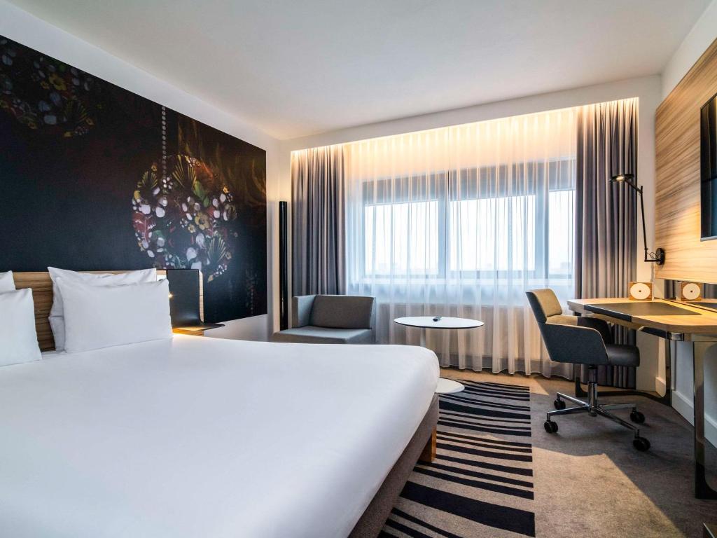 Pokój hotelowy z łóżkiem i biurkiem w obiekcie Novotel Amsterdam City w Amsterdamie