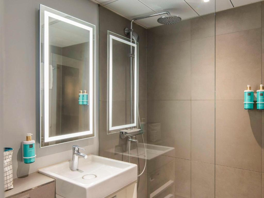 a bathroom with a sink and a shower at Novotel Amsterdam City in Amsterdam