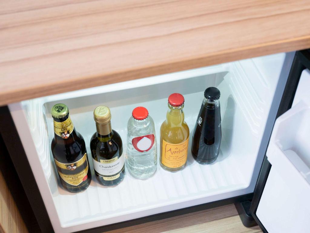 four bottles of wine in a refrigerator drawer at Novotel Amsterdam City in Amsterdam