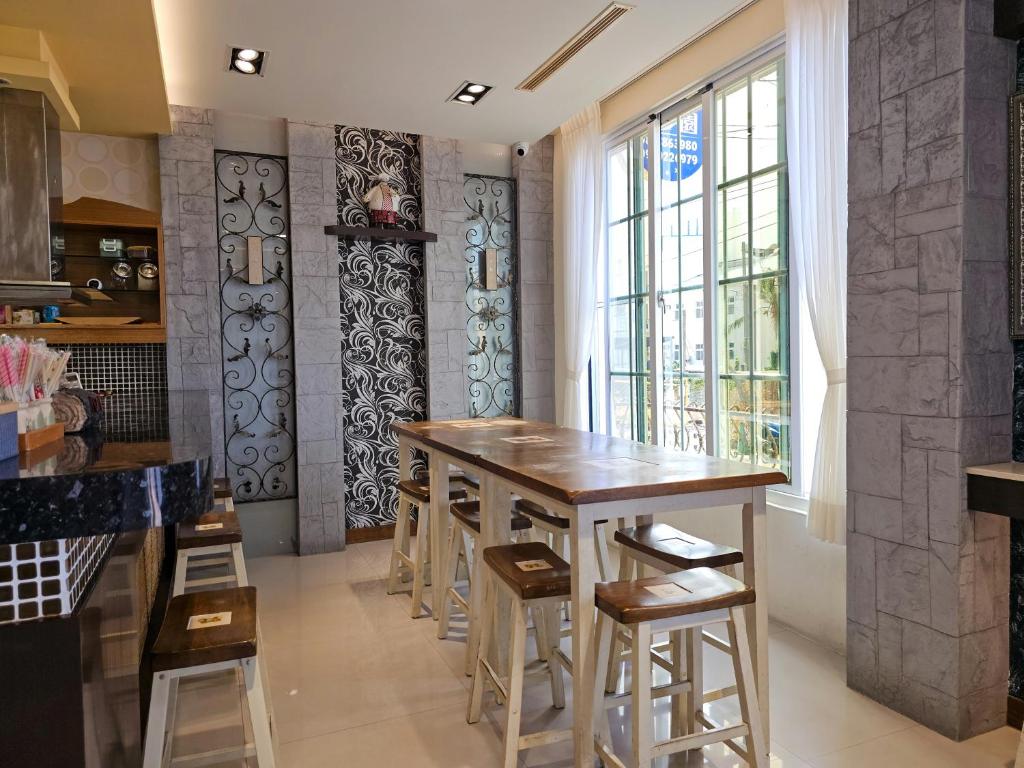 a kitchen with a wooden table and stools at Kenting Garden Homestay in Kenting