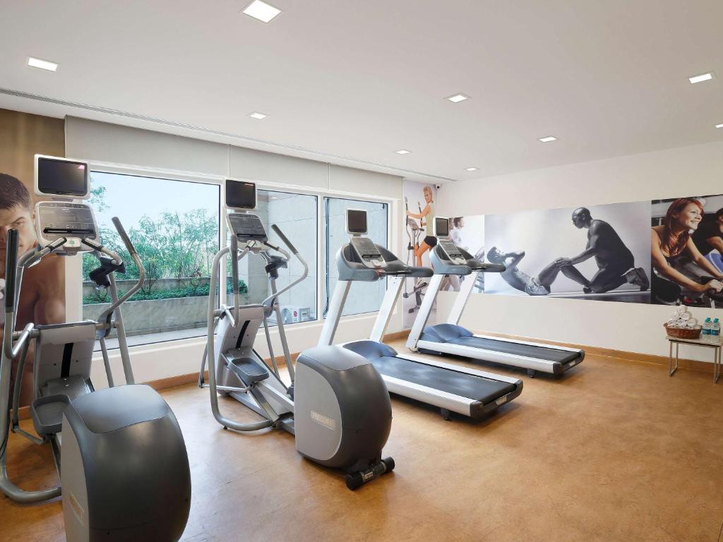 a gym with cardio equipment and a large window at ibis Pune Viman Nagar - An Accor Brand in Pune