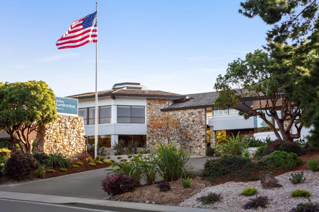 een gebouw met een Amerikaanse vlag ervoor bij Hilton Garden Inn Monterey in Monterey