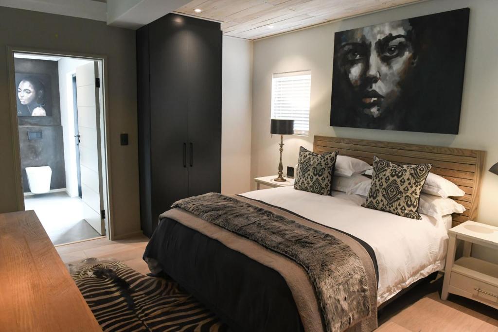 a bedroom with a bed and a large painting on the wall at Sleeping Beauty in Knysna