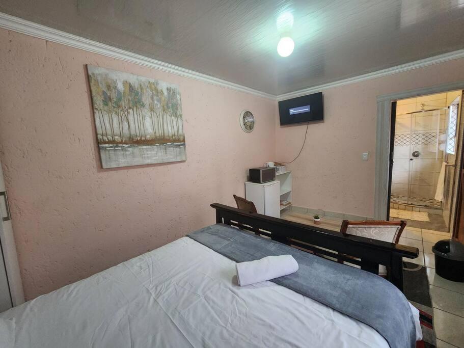 um quarto com uma cama com uma toalha em Private outside room with own bathroom em Joanesburgo