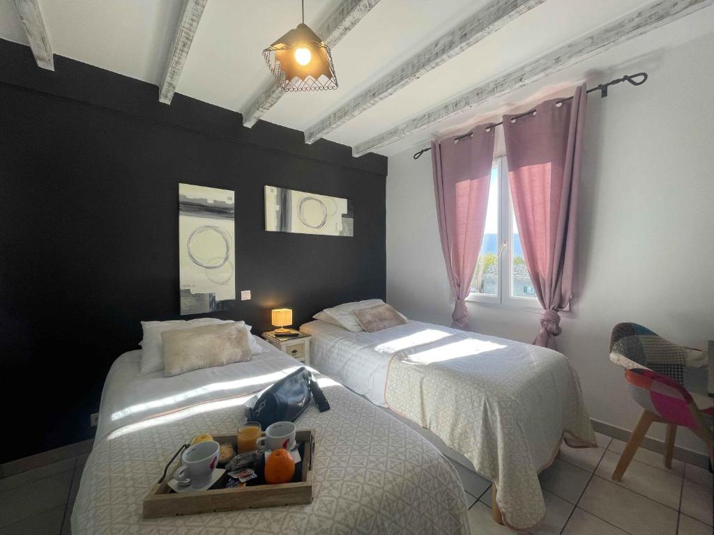 CoustelletにあるLes Loges du Luberonのベッドルーム1室(ベッド2台、食料品のトレイ付)