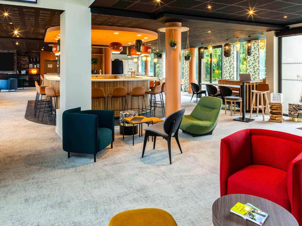 a lobby with chairs and tables and a bar at Mercure Agen Centre in Agen