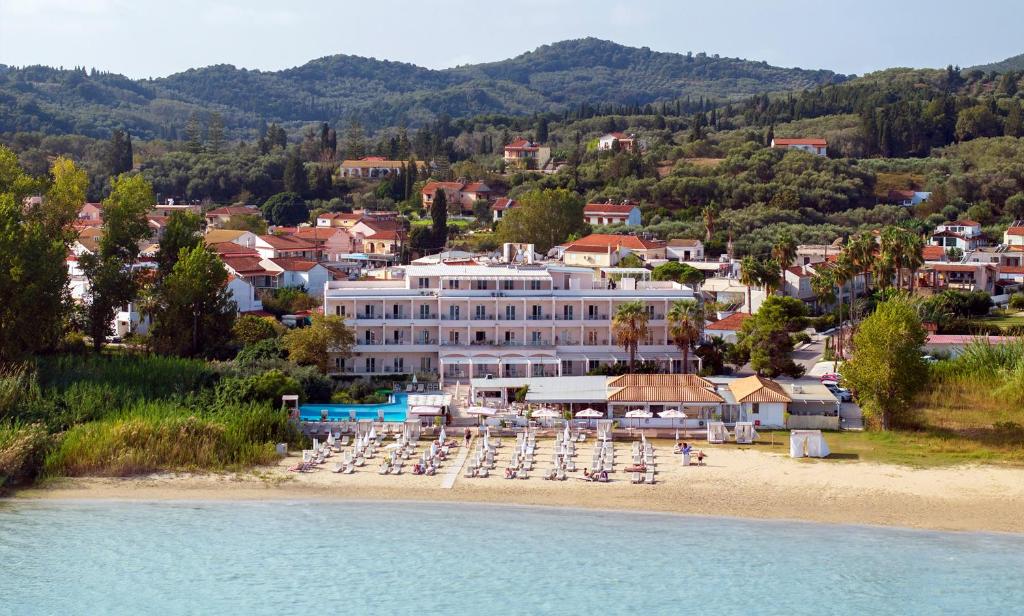 un hotel en una playa con sillas y sombrillas en Cavomarina Beach- Adults Only en Kávos