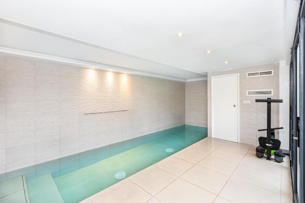 a swimming pool in the middle of a room at Luxury 3BR Flat, Parking & Garden, NW London in London