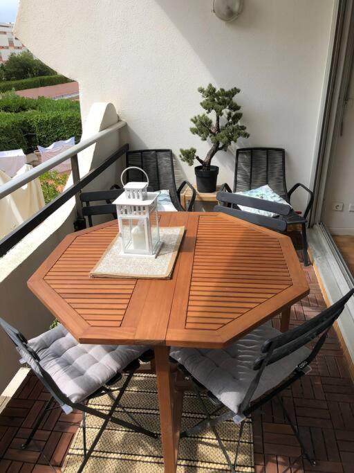 une table et des chaises en bois sur un balcon dans l'établissement Centre ville - Amiral 2 / 100m de la plage, à La Grande Motte