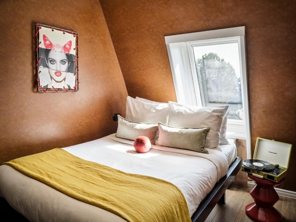 a bed with a red apple sitting on top of it at Max Brown Hotel Museum Square, part of Sircle Collection in Amsterdam