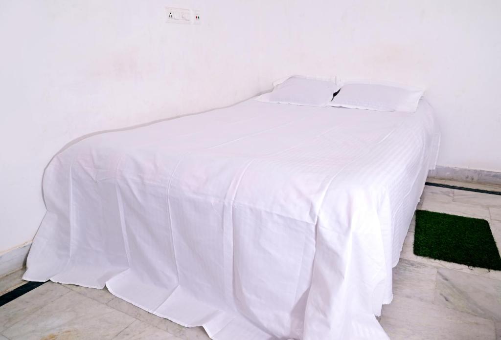 a white bed with a white sheet on it at Shivay Guest house in Jasidih