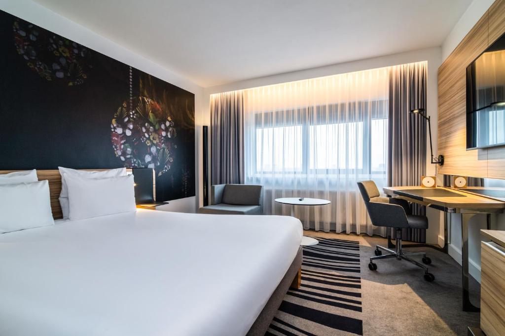 a hotel room with a bed and a desk at Novotel Amsterdam City in Amsterdam