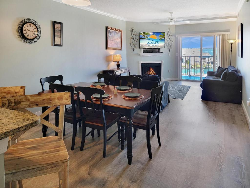 大洋城的住宿－Mariners Watch 304 - Luxury Bayview Condo，客厅配有桌椅和壁炉