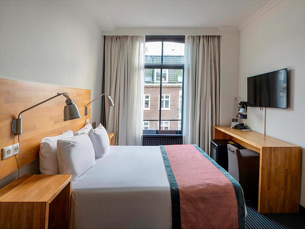 une chambre d'hôtel avec un lit et une télévision dans l'établissement Catalonia Vondel Amsterdam, à Amsterdam