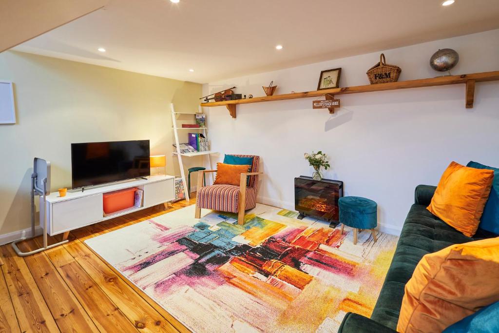 a living room with a couch and a flat screen tv at Host & Stay - Millers Coach House in Hexham