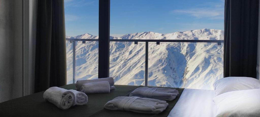 a bedroom with a view of a snowy mountain at Segreto Apartments New Gudauri in Gudauri